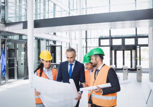 Businessman discussing on blueprint with architects in office building
